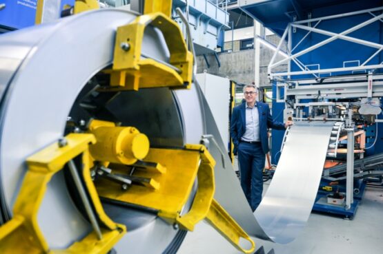 Bild einer Versuchsanlage am Institut für Umformtechnik der Universität Stuttgart. Im Hintergrund Institutsleiter Prof. Mathias Liewald. | Quelle: Universität Stuttgart / Max Kovalenko